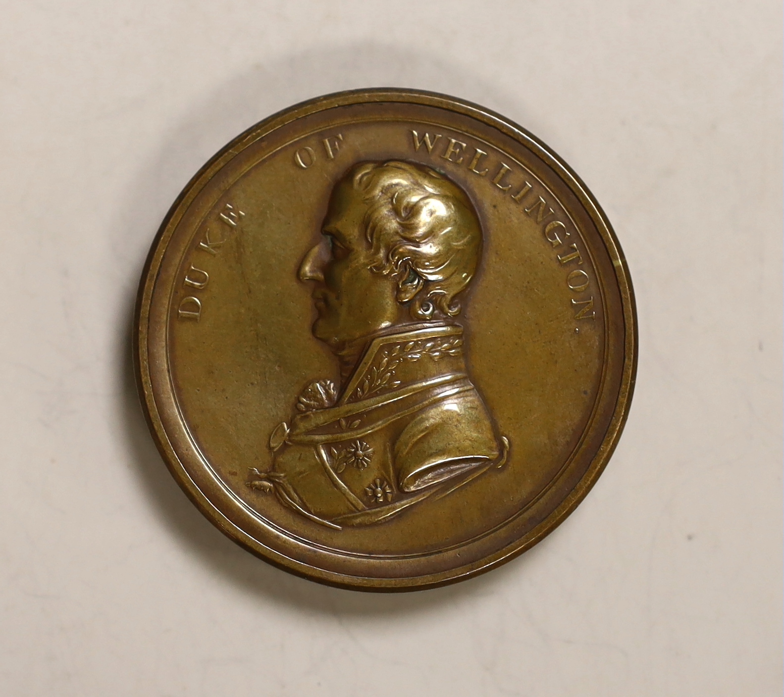 A cylindrical box formed in the shape of a coin commemorating The Duke of Wellington's Continental Victories, 4.7cm